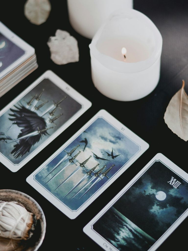 Tarot cards laid out beside a lit candle and crystals